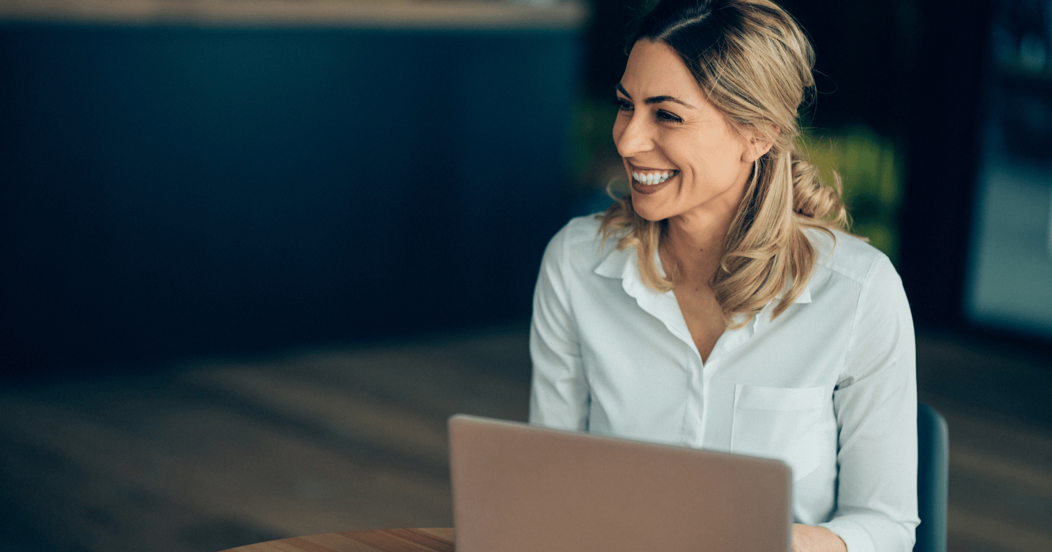 Woman smiling as she works on her laptop