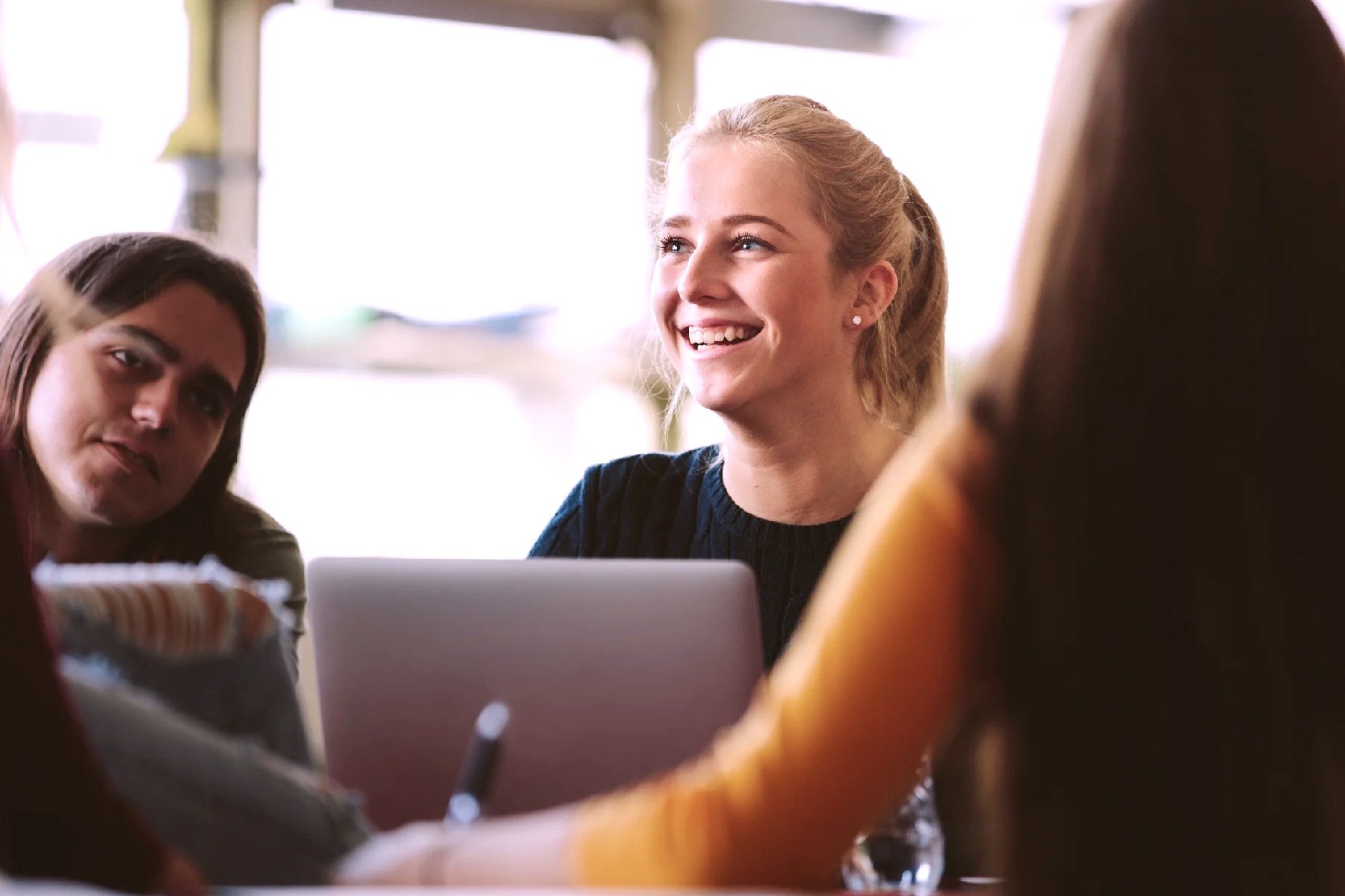 woman smiling in office with colleagues copy